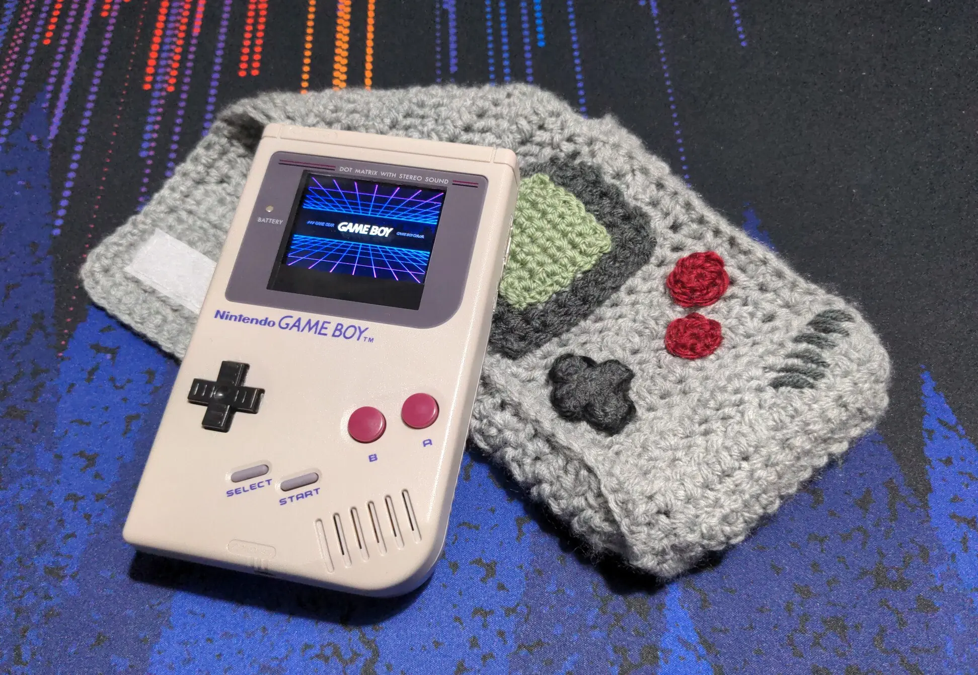 Image of a Raspberry Pi modified DMG-01 Gameboy resting on a crocheted pouch